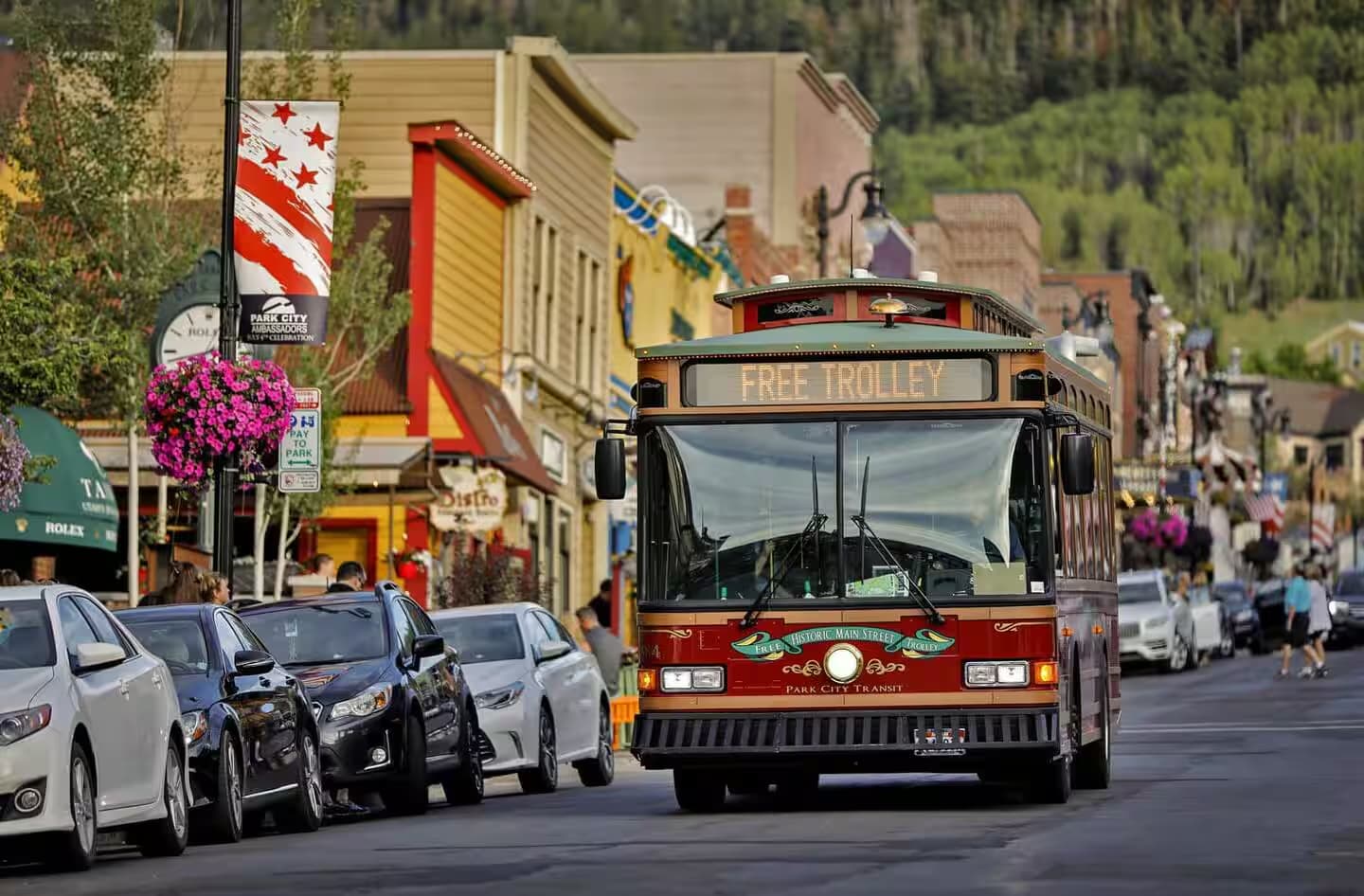 Park City's free trolley driving down Main Street past shops and parked cars