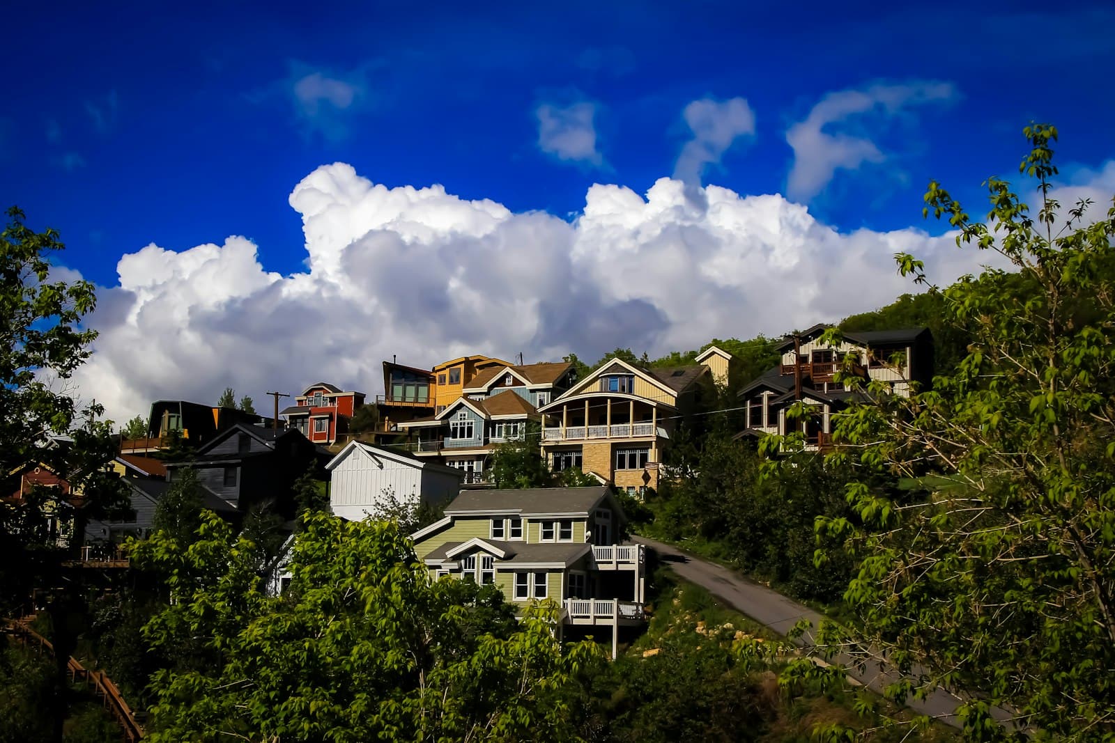 Hillside homes in Park City surrounded by green trees under a summer sky