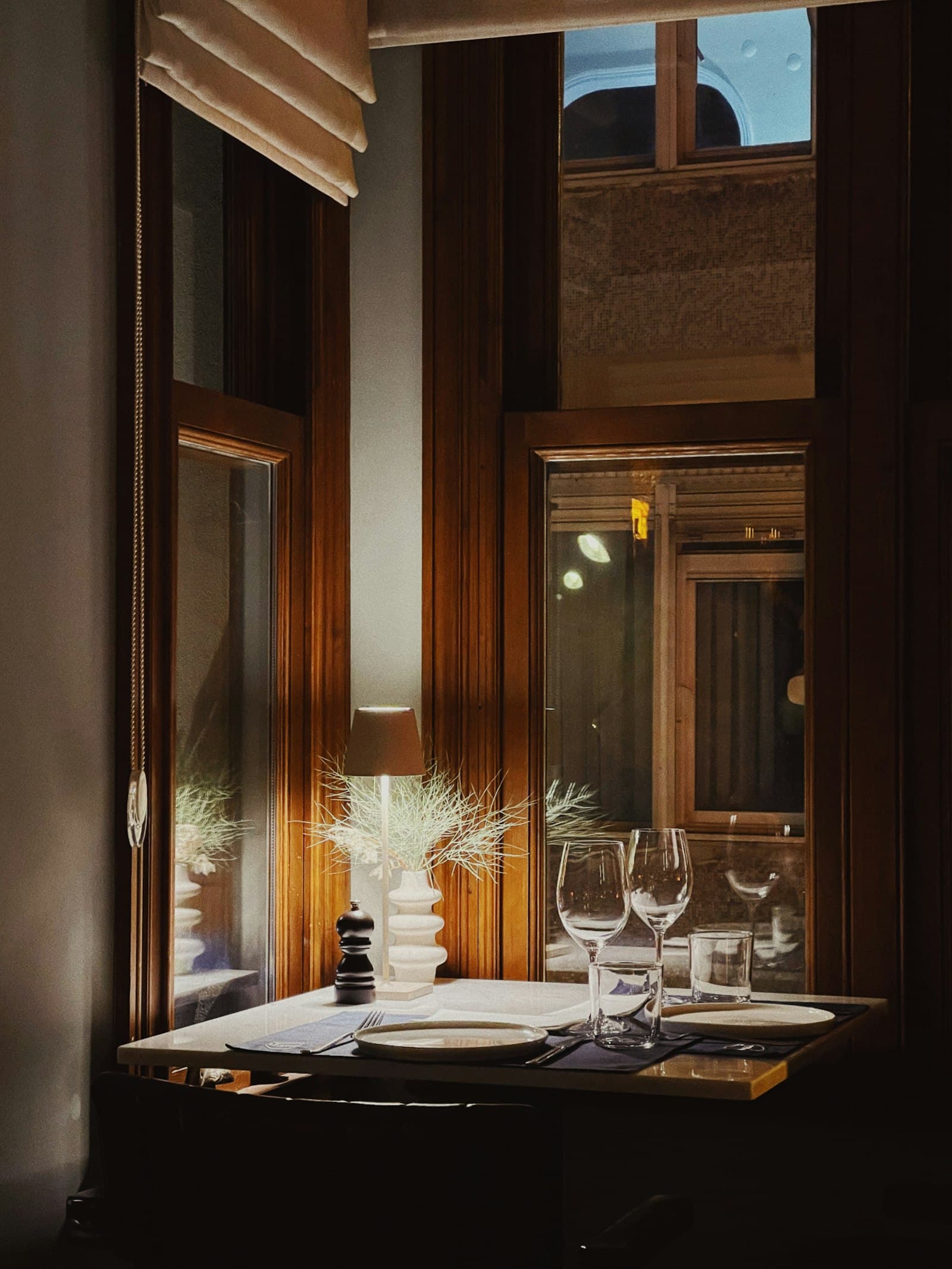 Intimate fine-dining table for two set with wine glasses in warm light
