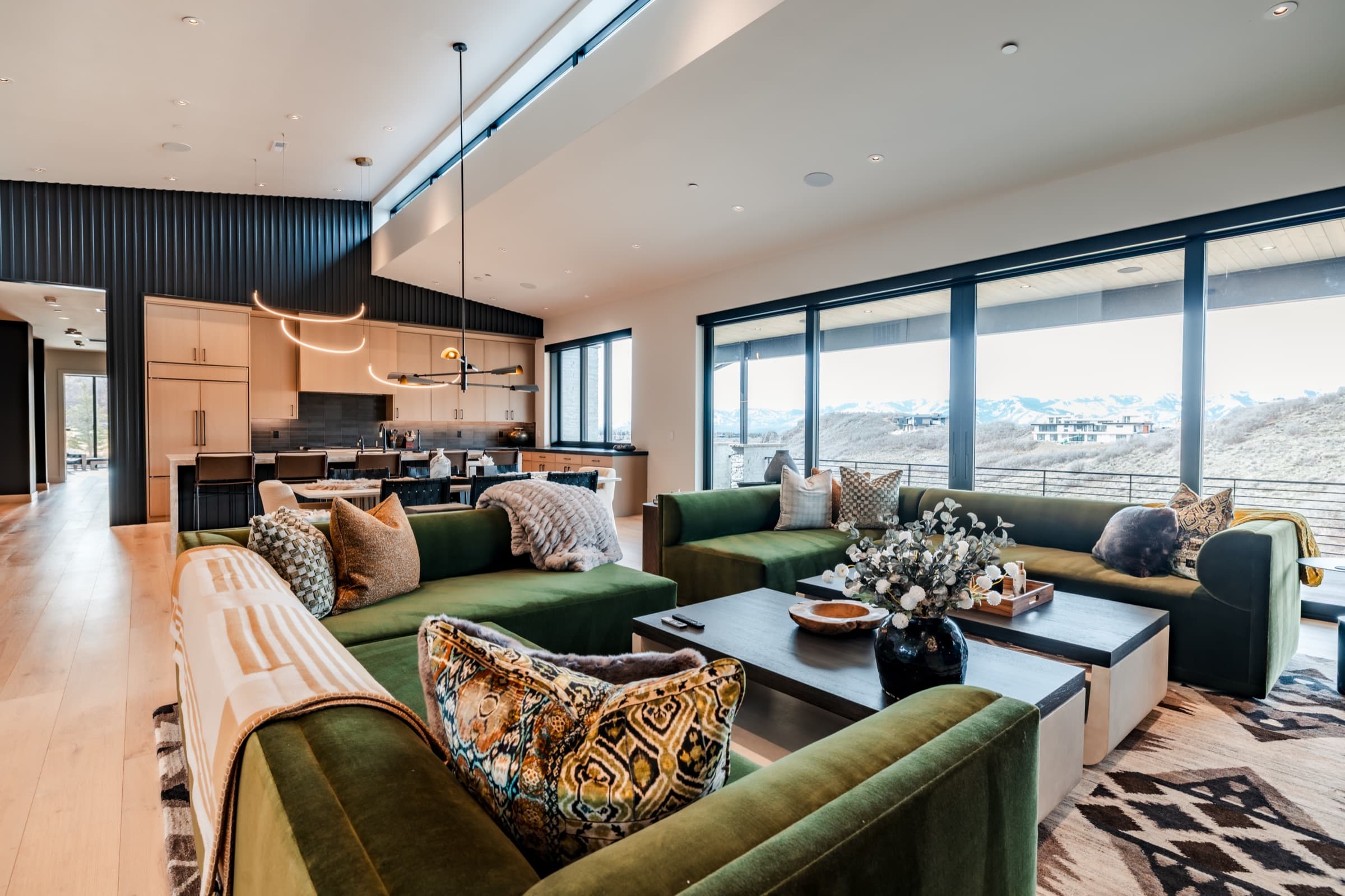 Great room with green velvet seating and mountain views in a luxury Park City home