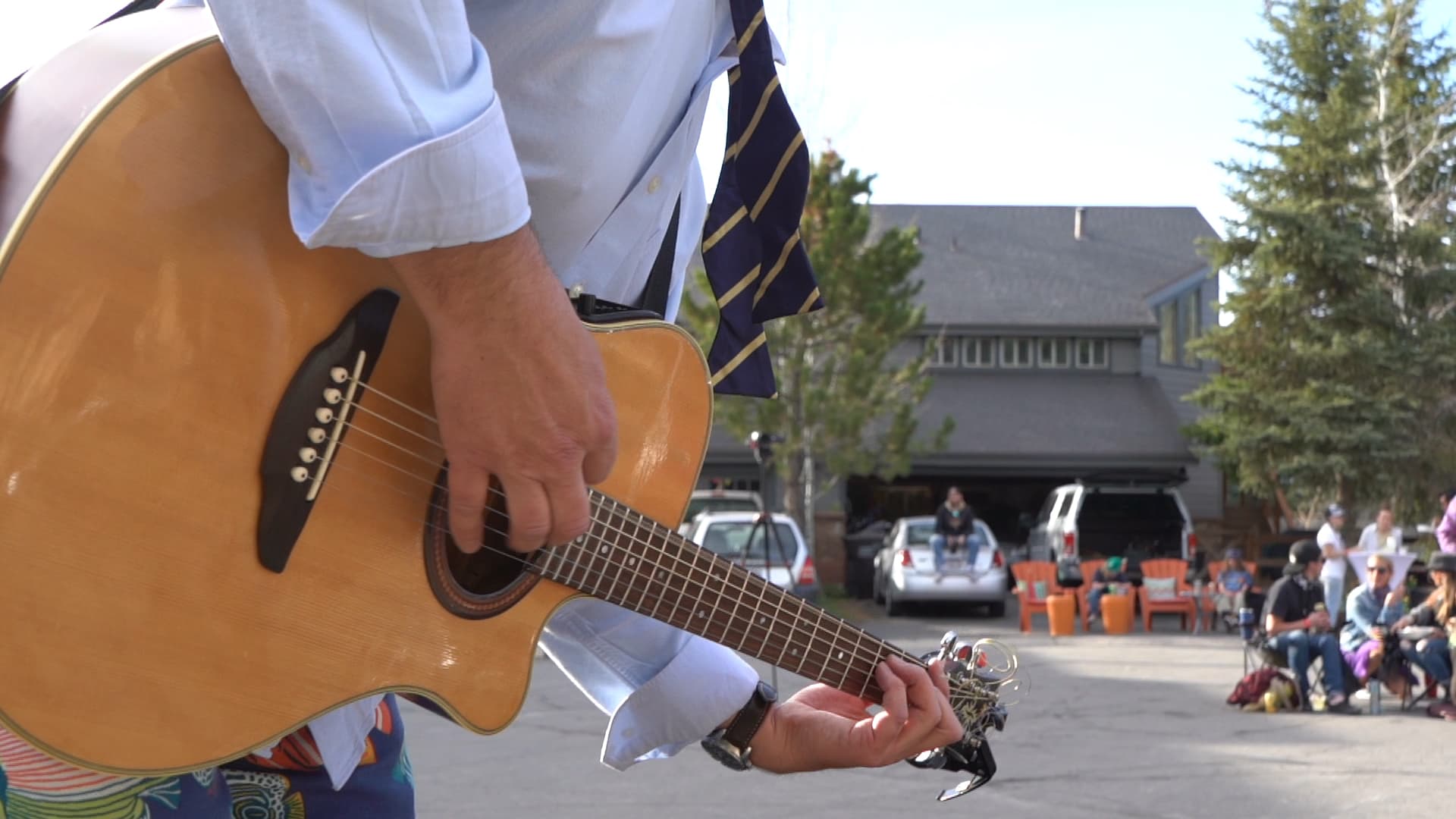 Musician playing acoustic guitar at an outdoor Park City concert