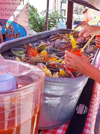 Vendor serving garnished Bloody Mary cocktails from a galvanized tub at the Park Silly Sunday Market